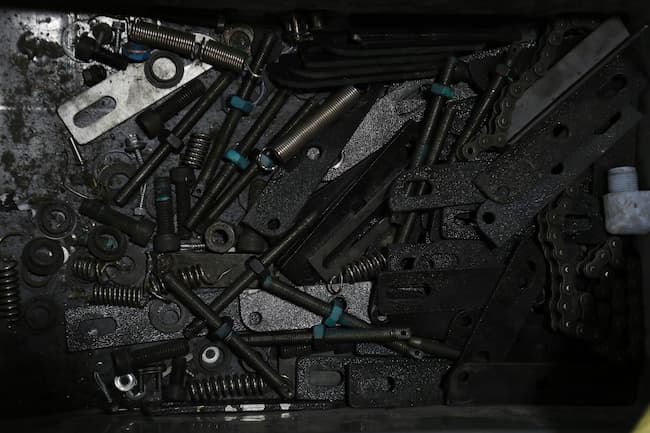pile of bolts, springs, braces, and screws
